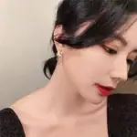 Une femme portant une boucle d'oreille en forme de croissant avec une étoile, mettant en valeur un style sophistiqué et moderne.