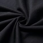 Tissu noir enroulé en spirale, texture douce et élégante, idéal pour la décoration ou la couture.