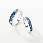 Anéis de aço com motivo oceânico em esmalte azul, perfeitos para simbolizar o amor e a paixão ligados ao mar.