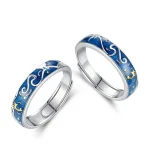 Anéis de casamento em metal com motivo celeste em esmalte azul e detalhes dourados, simbolizando o universo e a conexão eterna.