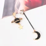 Alfinetes de bolsa com padrões de astronomia, estrelas e lua, em metal dourado com detalhes pretos e claros, perfeitos para acessórios de moda inspirados no espaço.