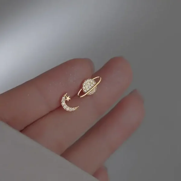 Joia de orelha em forma de lua e estrela adornada com diamantes, simbolizando a celestialidade e a elegância.