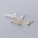 Brincos em forma de moléculas com pedras preciosas, design elegante e científico, perfeitos para os amantes de ciência e joias sofisticadas.