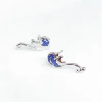 Brincos em forma de sereia em prata com detalhes em azul marinho, perfeitos para os amantes de joias inspiradas no mar e na ciência.
