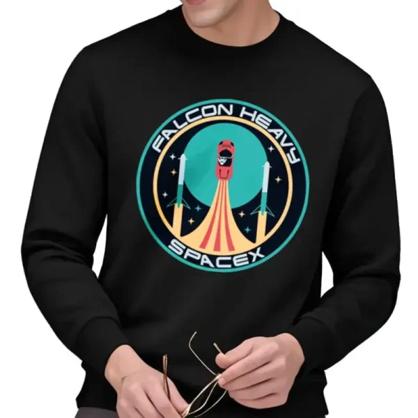 T-shirt preta com logotipo Falcon Heavy SpaceX, representando um foguete em lançamento com um fundo estrelado, ideal para entusiastas de aeroespacial e tecnologia espacial.