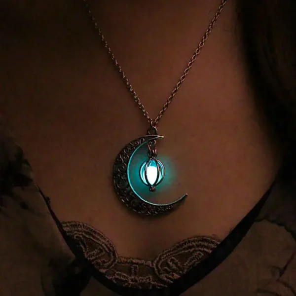 Pingente de lua e estrela luminoso suspenso em uma corrente, iluminando suavemente no escuro, ideal para decoração ou como joia original.
