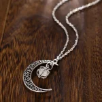 Pingente de lua em metal prateado com pulseira de corrente, joia de estilo cósmico e místico.