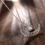 Colar com pingente de lua em metal finamente gravado e pedra central, ideal para um toque elegante e místico.