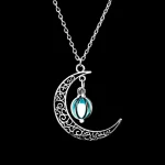 Pingente em forma de lua com um padrão ornamentado e um pingente molecular em vidro azul, suspenso em uma corrente de prata. Uma joia científica elegante e original.
