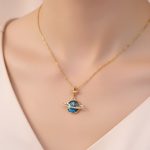 Pingente de Saturno em ouro com estrela e pedras preciosas, símbolo da astronomia e do universo, perfeito para amantes da ciência e decoração cósmica.