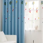 Cortina azul com desenhos de foguetes, planetas e estrelas, decorando uma janela de quarto infantil.