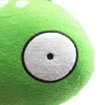 Pelúcia verde com olho grande e expressão engraçada, vista de perto, detalhe do pormenor do tecido macio.