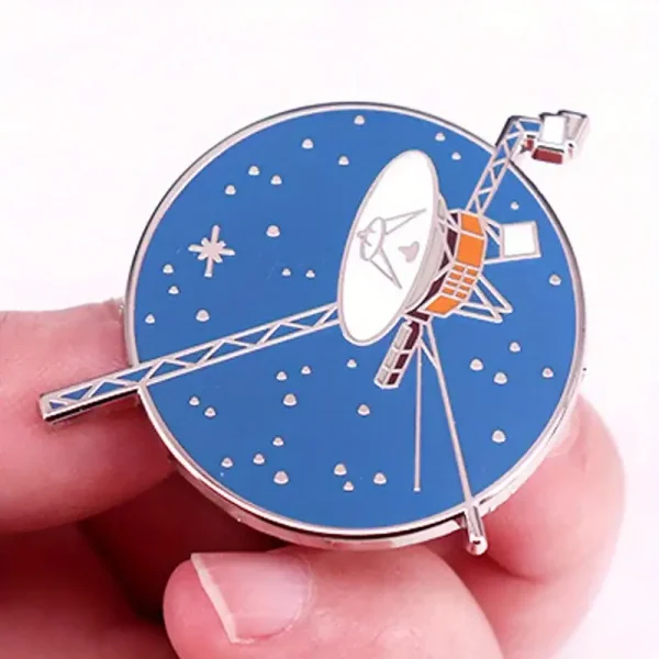 Relógio decorativo em forma de satélite com mostrador azul e detalhes metálicos.