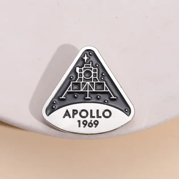 Uma broche ou badge representando a missão Apollo 11 da NASA, com a data 1969, símbolo emblemático da exploração espacial.