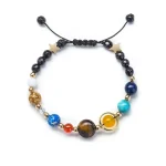 Pulseira de contas com cores variadas, estrelas douradas e fecho ajustável de cordão.