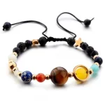 Pulseira com contas de minerais, incluindo uma esfera azul, uma esfera marrom, uma esfera amarela e contas de diferentes cores e tamanhos, com fecho ajustável.