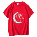 T-shirt vermelha com ilustração de uma astronauta flutuando perto de uma lua estilizada, rodeada de planetas e estrelas, perfeita para os amantes do espaço e da ciência.