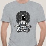 Camiseta cinza com ilustração de astronauta sentado diante de um padrão geométrico complexo, estilo artístico moderno e científico.