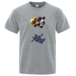 T-shirt cinza com ilustração de um astronauta flutuando no espaço sob um grupo de planetas coloridos. Perfeito para os amantes de ciência e astronomia.