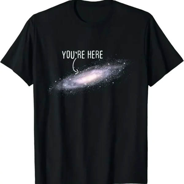 T-shirt galáxia com texto "You're Here" em branco sobre fundo preto, representando uma galáxia espiral com uma mensagem humorística e cósmica.