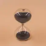 Horloge de sable en verre avec sable noir et transparent, design élégant et moderne, parfait pour la décoration scientifique ou comme objet de collection.