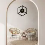 Horloge murale en forme de cube avec design minimaliste, noir et doré, ajoutant une touche contemporaine à la décoration intérieure.