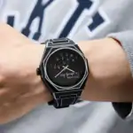 Montre scientifique moderne avec cadran noir et design épuré, portée au poignet d'une personne.