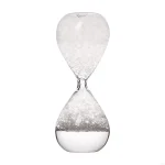 Ampulheta de vidro transparente com areia branca fina, símbolo do tempo que passa e da paciência, perfeita para decoração científica ou educativa.
