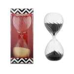 Ampulheta decorativa em vidro preto e branco, símbolo do tempo, ideal para decoração interior ou como objeto de coleção.
