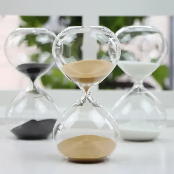 Ampulheta em vidro com areia branca e preta, símbolo do tempo que passa, decorativa e científica, ideal para decoração de escritório ou prateleira.