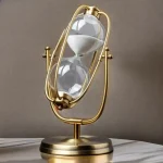Ampulheta decorativa em latão dourado com vidro em forma de lâmpada, ideal para decoração científica ou vintage.