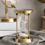 Ampulheta em metal vintage com moldura em latão e vidro, decorativa para uma decoração científica ou vintage.