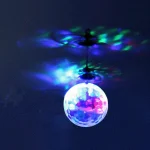 Lâmpada suspensa em forma de bola projetando luzes coloridas no teto, criando um ambiente luminoso e artístico.