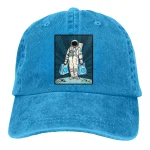 Boné em denim azul com patch de astronauta ilustrado, perfeito para entusiastas de ciência e exploração espacial.
