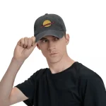 Jovem usando um boné preto com um logotipo de planeta, olhando para a direita, fundo branco.