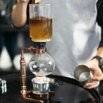 Dispositivo de destilação de laboratório com líquido em ebulição, usado para a separação de substâncias químicas.