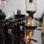 Dispositivo de laboratório com garrafa de café preto, equipamento científico para experiências ou decoração temática científica.