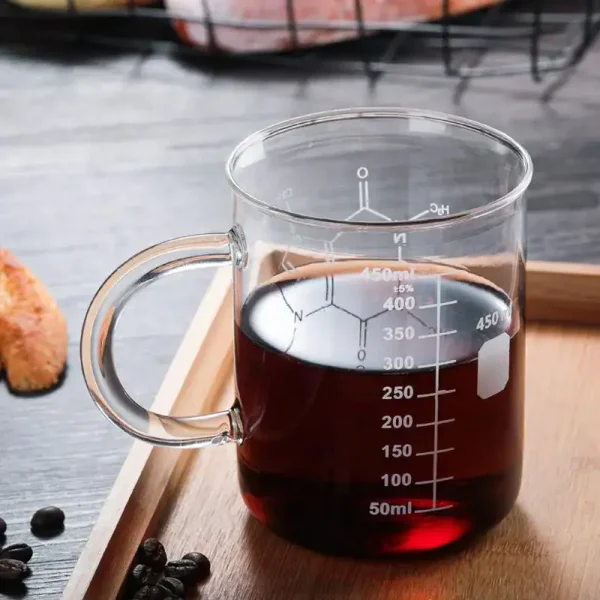 Caneca de laboratório em vidro contendo um líquido escuro, graduada para medir precisamente o volume, ideal para experiências científicas ou decoração temática.