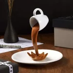 Caneca de café original em forma de seringa, com líquido achocolatado escorrendo em um prato, ideal para decoração de cozinha ou presente inusitado.
