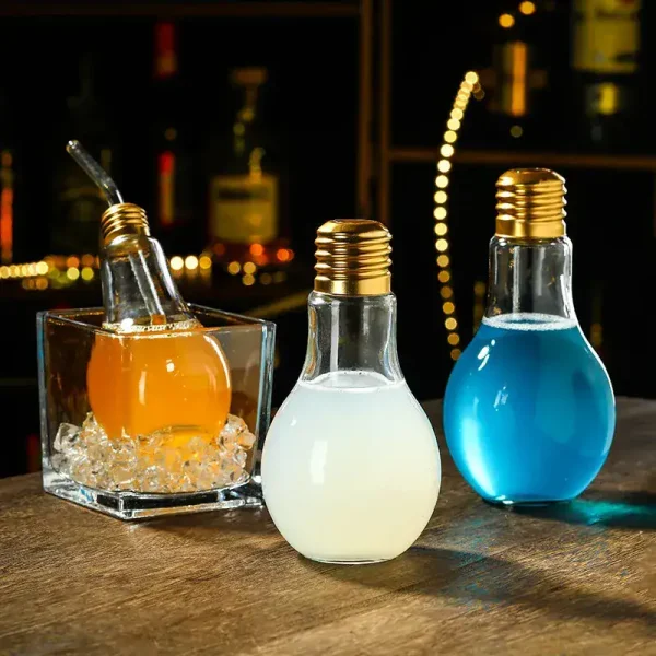 Três lâmpadas decorativas preenchidas com líquidos coloridos (laranja, branco, azul) sobre uma mesa de madeira, ambiente acolhedor e moderno.