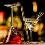 Copo de cocktail científico com líquido vermelho, pipeta e decoração em forma de coração, perfeito para uma decoração de ciência ou evento temático.
