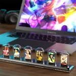Vitrine com figuras de personagens científicos e educativos, apresentada em frente a um laptop exibindo uma ilustração colorida.