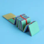 Conjunto de cartas educativas em papel colorido, dobráveis, com uma faixa vermelha para fixação, dispostas sobre um fundo azul claro.