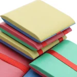 Conjunto de blocos de notas coloridos empilhados com elásticos, perfeitos para anotações e organização de escritório.