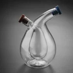 Balão de vidro de laboratório com dois colos inclinados, ideal para experiências científicas ou decoração.