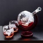 Objeto científico decorativo com globo terrestre e líquido vermelho em um suporte de madeira.