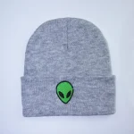 Gorro cinza de lã com patch de alienígena verde bordado, ideal para um estilo casual e original. Perfeito para os fãs de ficção científica e design único.