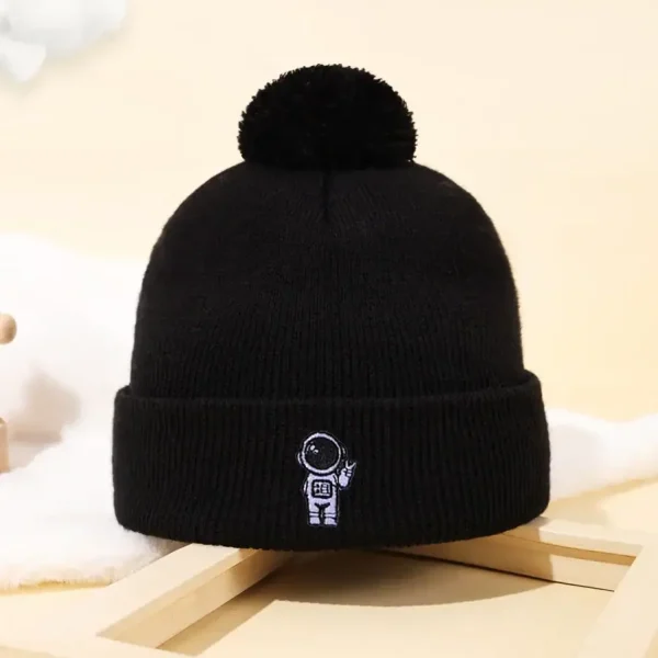 Gorro preto de lã com pompom e logotipo de um astronauta, ideal para os amantes de ciência e astronomia, perfeito para o inverno ou como acessório de decoração científica.