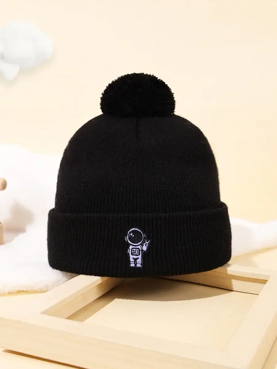 Gorro preto de lã com pompom e logotipo de um astronauta, ideal para os amantes de ciência e astronomia, perfeito para o inverno ou como acessório de decoração científica.
