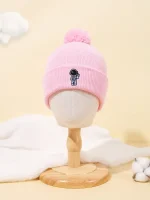 Chapéu de lã rosa com pequeno motivo de astronauta bordado, ideal para crianças ou entusiastas de ciência e espaço. Perfeito para manter a cabeça quente enquanto exibe um estilo lúdico.